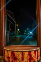 nighttime urban scene featuring a rusty metallic structure with a wooden top photo