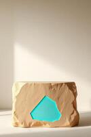 tan stone form with a cyan light cutout serves as a display stand. photo