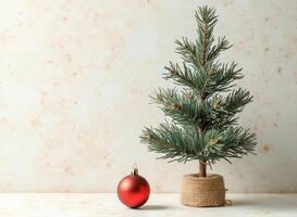 small artificial evergreen tree with red decorative sphere photo