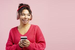 Smiling woman listening to music and using smartphone photo