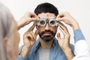 Optometrist examining patient's eyesight with phoropter during eye exam photo