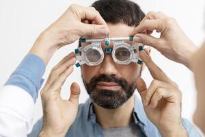 Optometrist performing eye exam on patient using phoropter photo