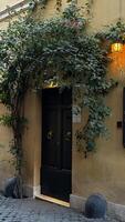 Charming entrance with lush greenery and warm lantern light in an old town, inviting exploration at dusk near historic buildings photo