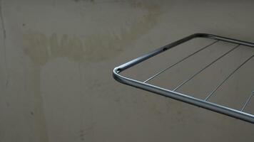 A Metal Drying Rack Positioned Elegantly Against a Bare Wall for Maximum Utility and Style photo