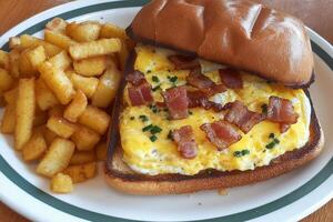 Delicious Egg and Bacon Sandwich with Crispy Potato Fries photo