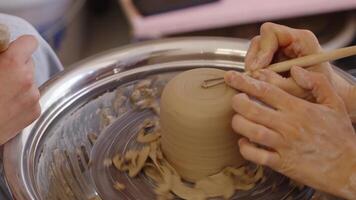 Creating a clay cup on a pottery wheel in an art studio video