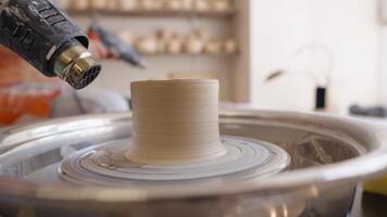 Creating a custom ceramic piece on the pottery wheel in a studio video