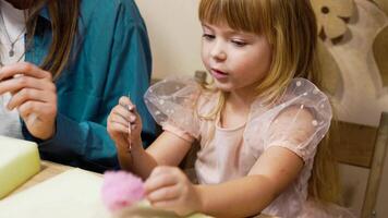 A girl enjoys crafting with colorful wool at a creative workshop video