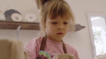 child creates pottery in a bright studio during a creative workshop video