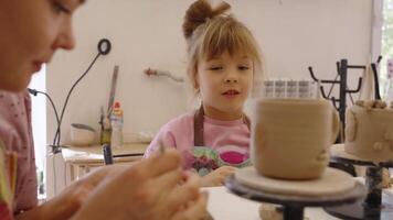 A young girl learns pottery skills in a creative workshop setting video