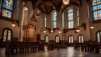 Inside a church, illuminated by natural light streaming through stained glass windows, with rows of wooden pews facing a decorated altar photo
