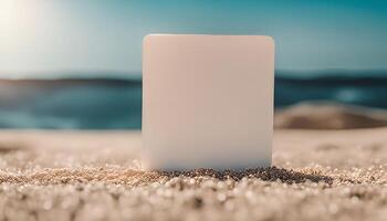 White Blank Card on a Sandy Beach with a Blue Ocean in the Background photo