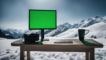 Computer Setup with Green Screen in Snowy Mountain photo