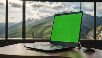 Laptop with Green Screen in Front of Mountain View photo