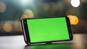 Smartphone with Green Screen on a Table with Bokeh Lights photo