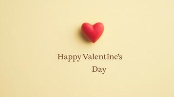 A small red heart placed above a message wishing a happy Valentine's Day. The heart symbolizes love and affection, making it a fitting decoration for this romantic occasion. photo