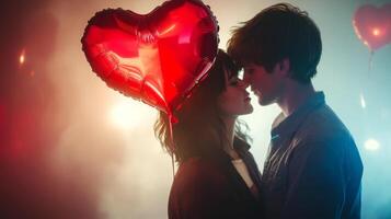 A young couple shares a tender moment, their foreheads touching as they gaze into each other's eyes. Heart-shaped balloons float in the background, creating a romantic atmosphere at a festive event. photo