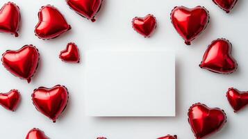 Heart-shaped balloons in vibrant red are arranged around a blank canvas, inviting creativity. The setting is bright and festive, perfect for celebrations or artistic projects. photo