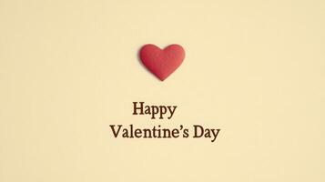 A red heart shape sits above the words wishing a happy Valentine's Day, set against a soft beige background. This simple yet charming design captures the spirit of love and affection. photo