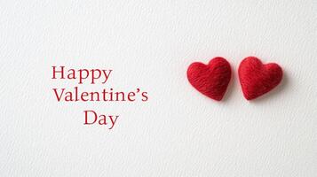 Two red felt hearts are positioned closely on a textured white background with the greeting expressing love for Valentine's Day. This simple yet meaningful setup captures the spirit of the occasion. photo