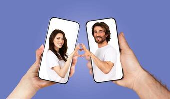 A couple connects emotionally through their smartphones, expressing love and affection. They create a heart shape with their hands while capturing the moment through an app. photo