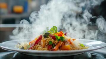 A vibrant dish of pasta topped with colorful vegetables sits on a plate, releasing steam. The background reveals a busy kitchen with chefs preparing other meals during meal service. photo