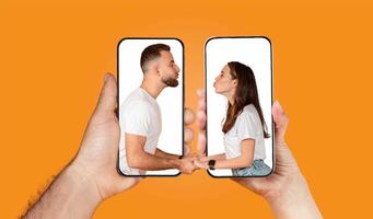 Two hands hold smartphones displaying a couple engaged in a loving chat, showcasing their connection through technology. The vibrant background emphasizes their interaction. photo