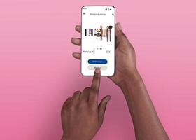 Female Shopping Concept. Above top overhead view of black woman browsing online make up store on her smart phone, isolated on pink background, touching screen. Customer ordering via internet photo