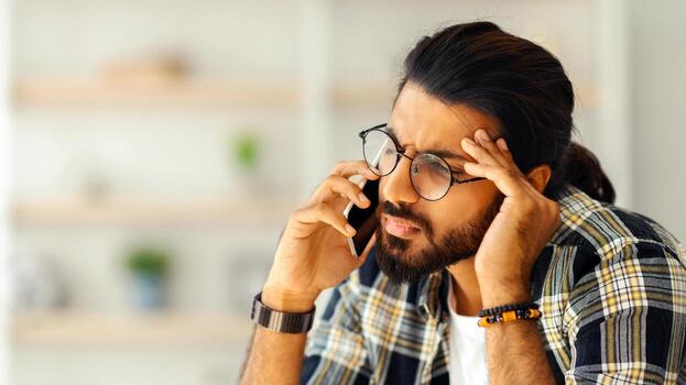 trastornado Medio este chico en casual sentado en sofá, teniendo teléfono conversacion con amante o negocio pareja, experimentando dificultades, hogar interior, Copiar espacio, de cerca retrato foto