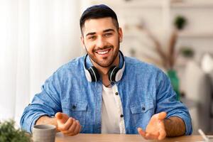 Portrait of smiling man making call, looking at camera and talking, discussing strategy with partners online, millennial guy recording webinar, hr manager holding distance job interview photo