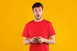 Surprised funny bearded man using smartphone, chatting online, typing sms, glad to recieve many messages, looking overjoyed at camera, connected to wireless internet, shocked by sale and discount photo