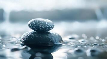 Two large rocks are sitting on top of each other in a body of water photo