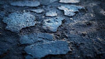 The image is of a cracked and broken pavement with a blue hue photo