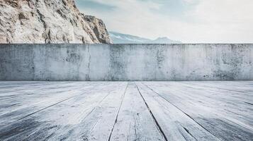 A large mountain range is visible in the background behind a concrete wall photo