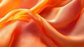 The orange fabric is flowing and has a smooth texture photo