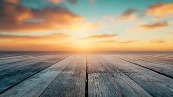 A wooden table with a view of the ocean and a sunset in the background photo