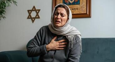 Emotional moment of middle eastern woman in headscarf reflecting on faith in home setting photo