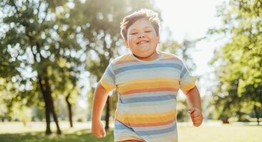 Joyful young caucasian boy running in summer park with sunlight photo