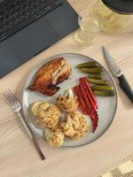 Delicious meal featuring roasted chicken and vegetables on a wooden table photo