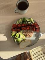 Healthy breakfast with fresh vegetables and bread served on a wooden table photo