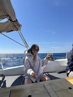Young woman enjoying a sunny day sailing on a boat in the ocean photo