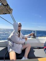 Woman enjoying a sunny day on a boat while relaxing by the ocean waves photo