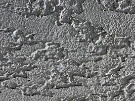 Textured wall surface with intricate patterns and shadows in natural light photo