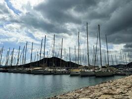 Sailboats docked at a marina under a cloudy sky in the late afternoon photo