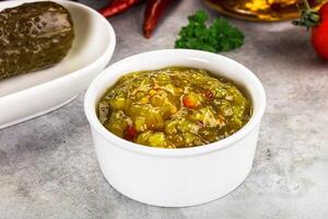 Souce gherkin relish with marinated cucumbers photo