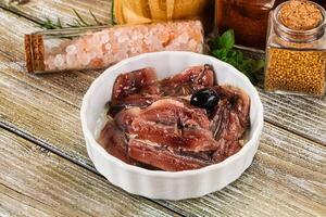 Canned anchovy with oil in the bowl photo