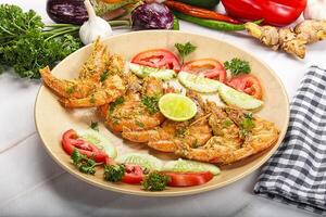 Grilled prawn served lime and vegetables photo