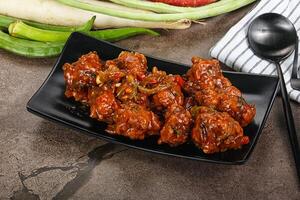 Manchurian chicken with sauce and spices photo