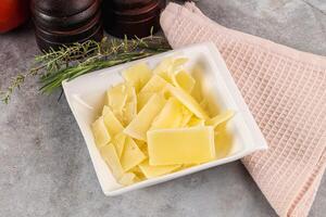 Parmesan cheese slices in the bowl photo