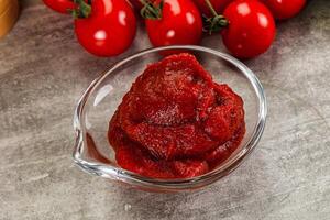 Red tomato paste in the bowl photo